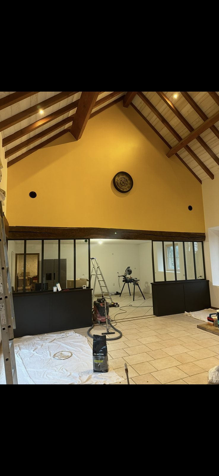 Mur pignon peint en jaune vif sous charpente apparente, peinture intérieure en Deux-Sèvres