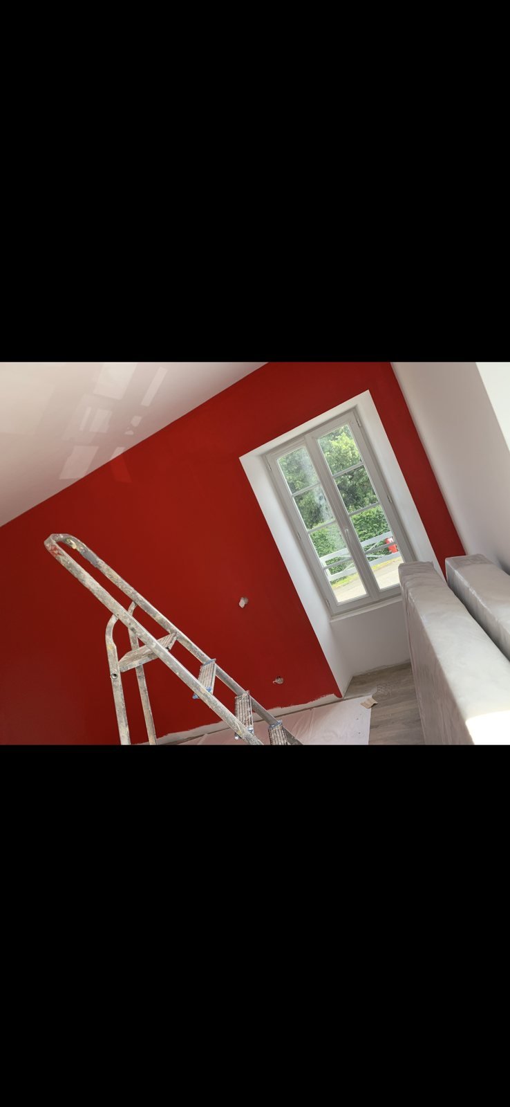 Mur de chambre sous pente peint en rouge, chantier de peinture intérieure en Deux-Sèvres
